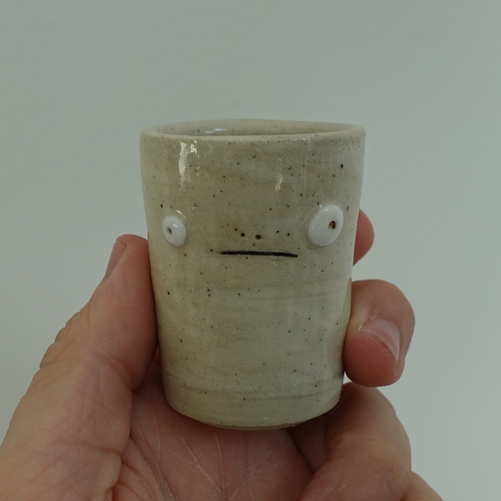 A shotglass with a blank expression
